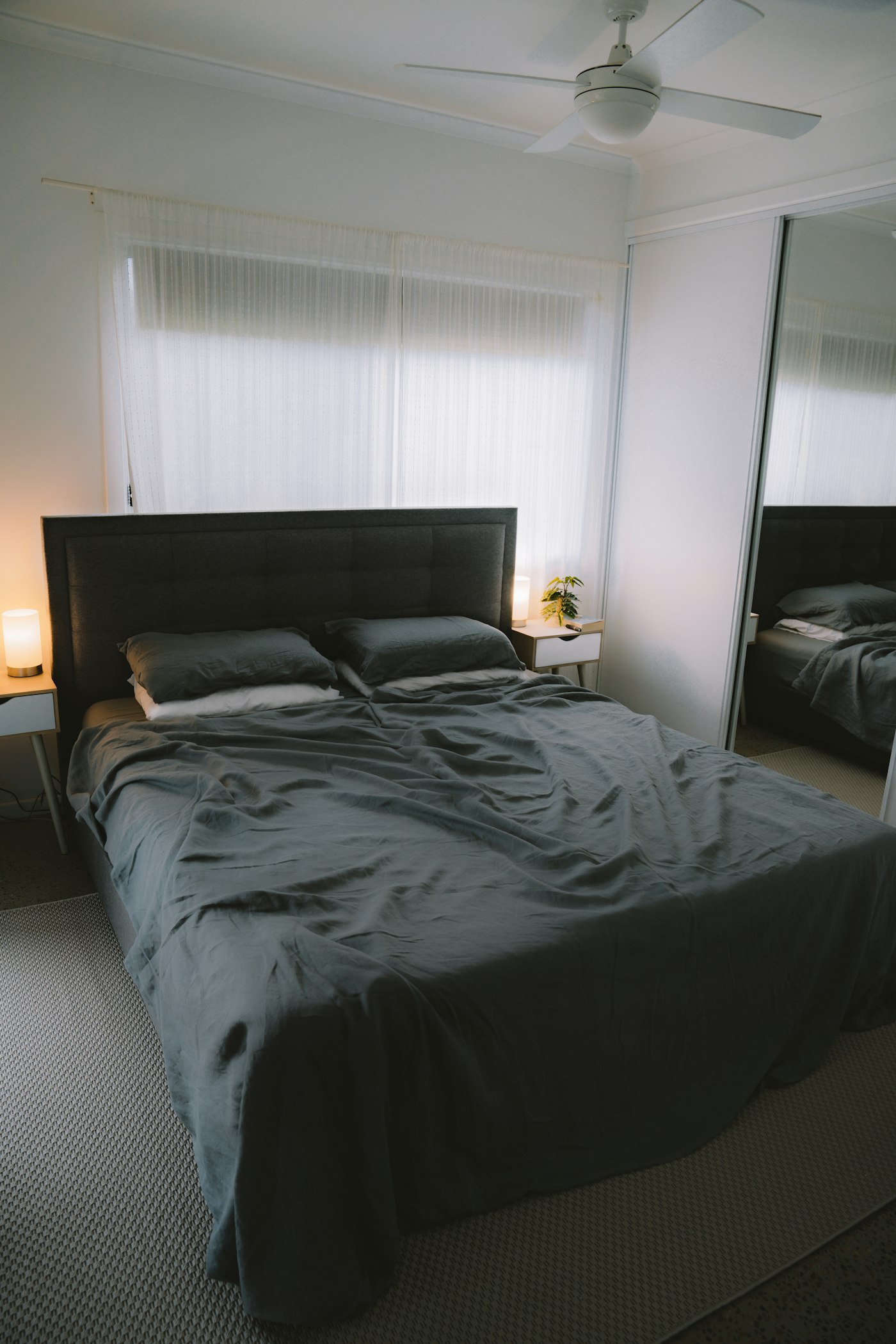 Dark fitted and flat sheets on a bed