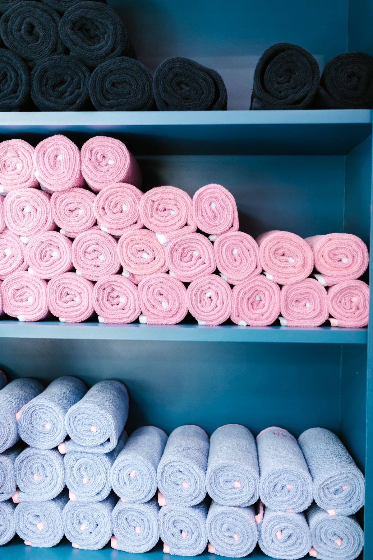 Rolled bath towels stacked on shelves